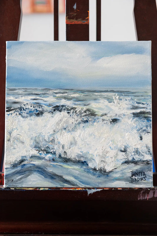 Original ocean wave oil painting titled "Alive" by Danita Brooks, displayed on an easel with natural light