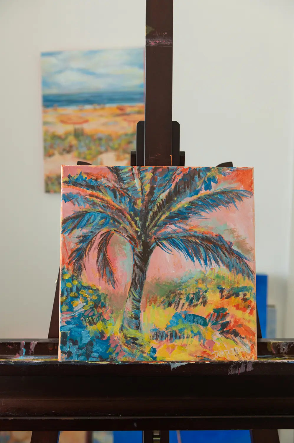 Original palm tree painting titled "Cotton Candy Skies" by Danita Brooks, shown on my easel and displayed in soft natural light