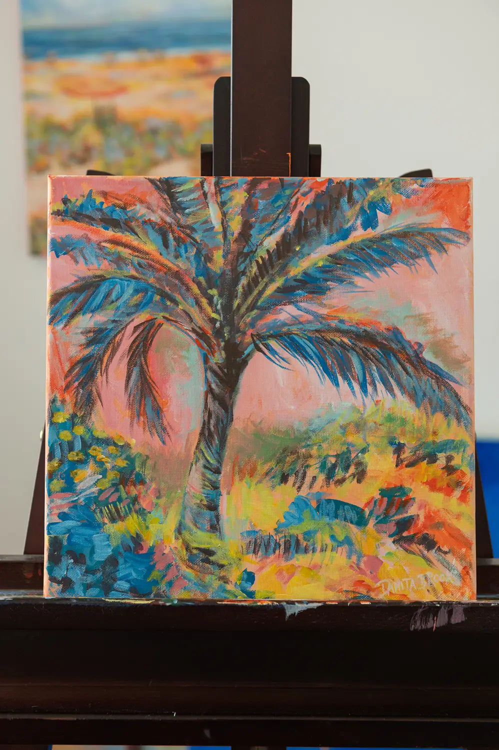 Closer straight view of original palm tree painting titled "Cotton Candy Skies" by Danita Brooks, framed in white plein air frame and displayed in soft natural light