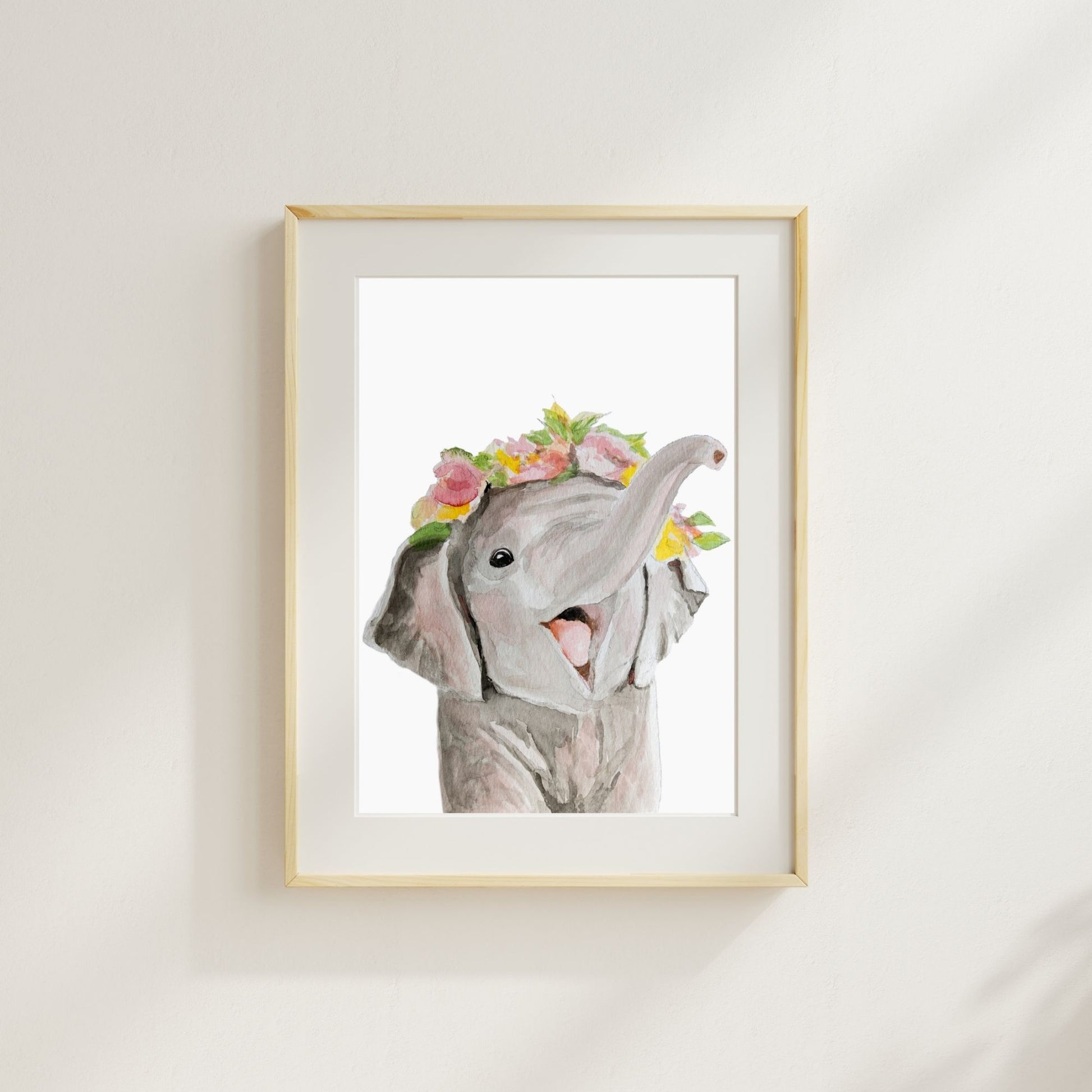 Elephant with flower crown watercolor print matted and framed on wall in nursery setting