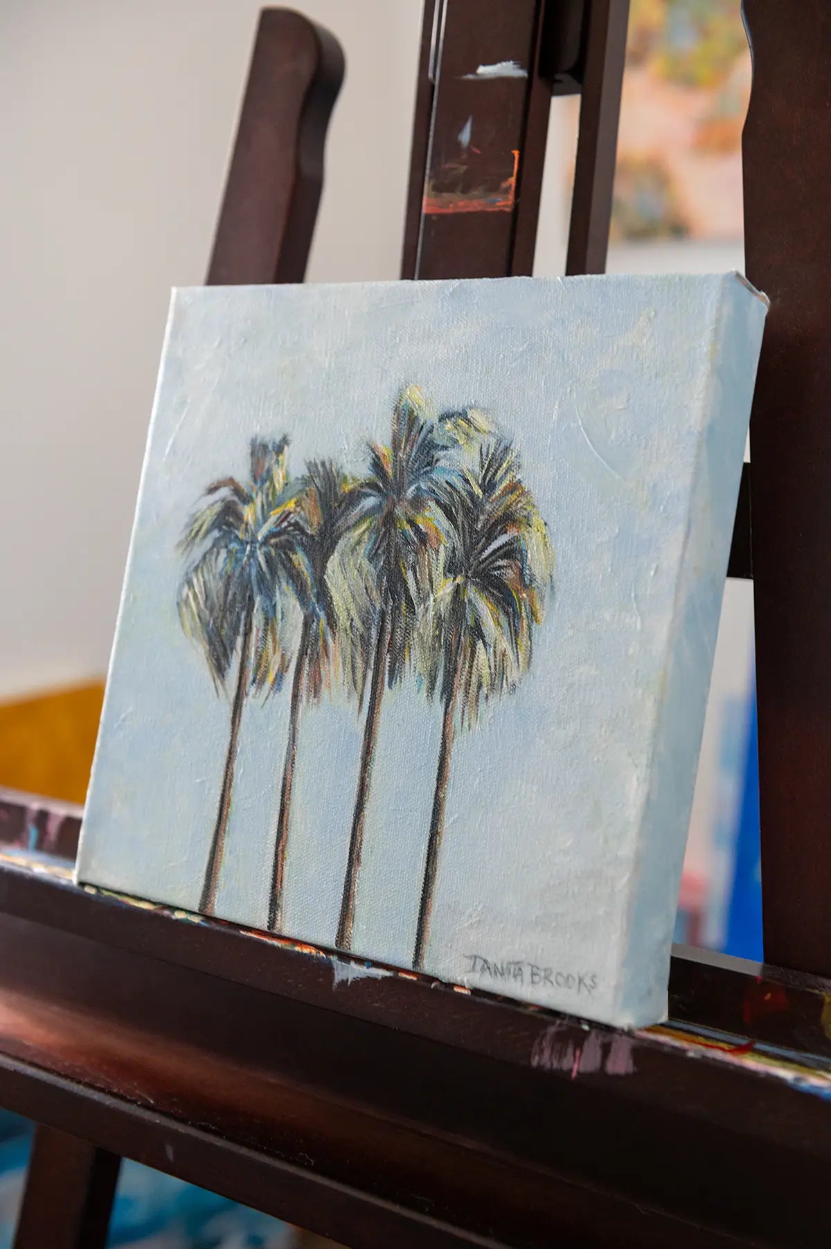 Side view of "Four Palms" tropical oil painting showing palm trees swaying against a soft summer sky