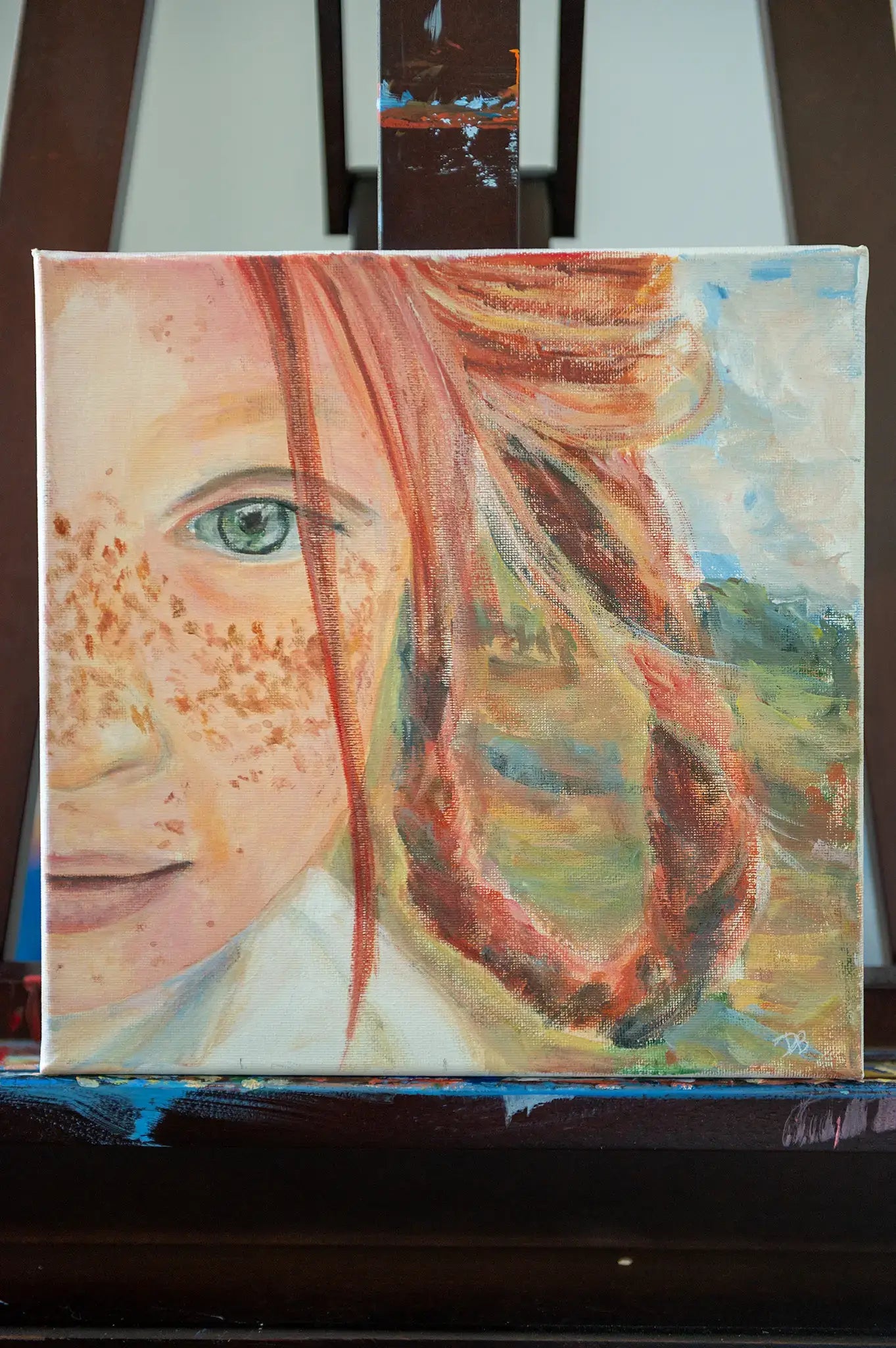 10x10 canvas painting titled “Freckles” by Danita Brooks, expressive portrait of girl with green eye and braid