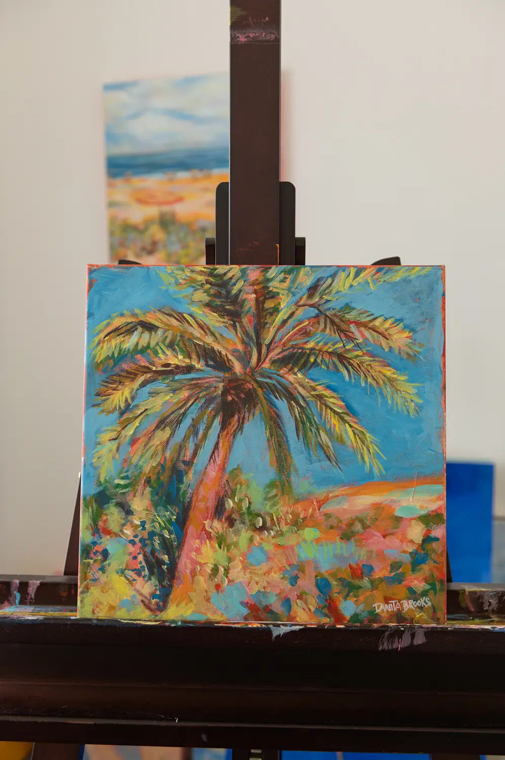 Original palm tree and sky painting titled "Clear Skies Ahead" by Danita Brooks, shown here on my easel and displayed in natural light