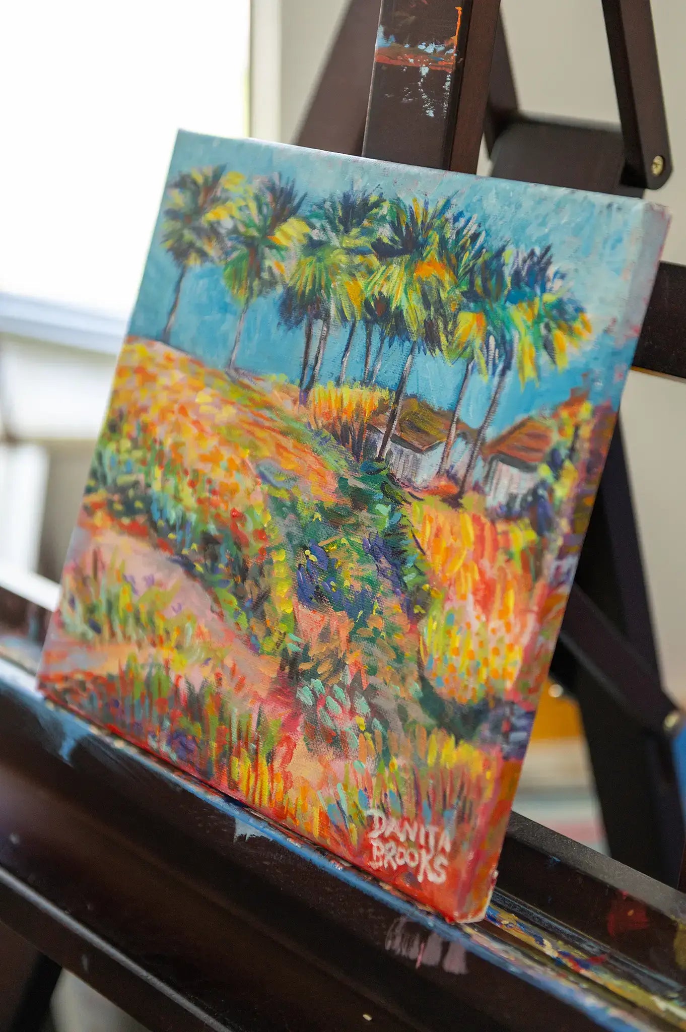 Angled shot of original tropical landscape painting by Danita Brooks
