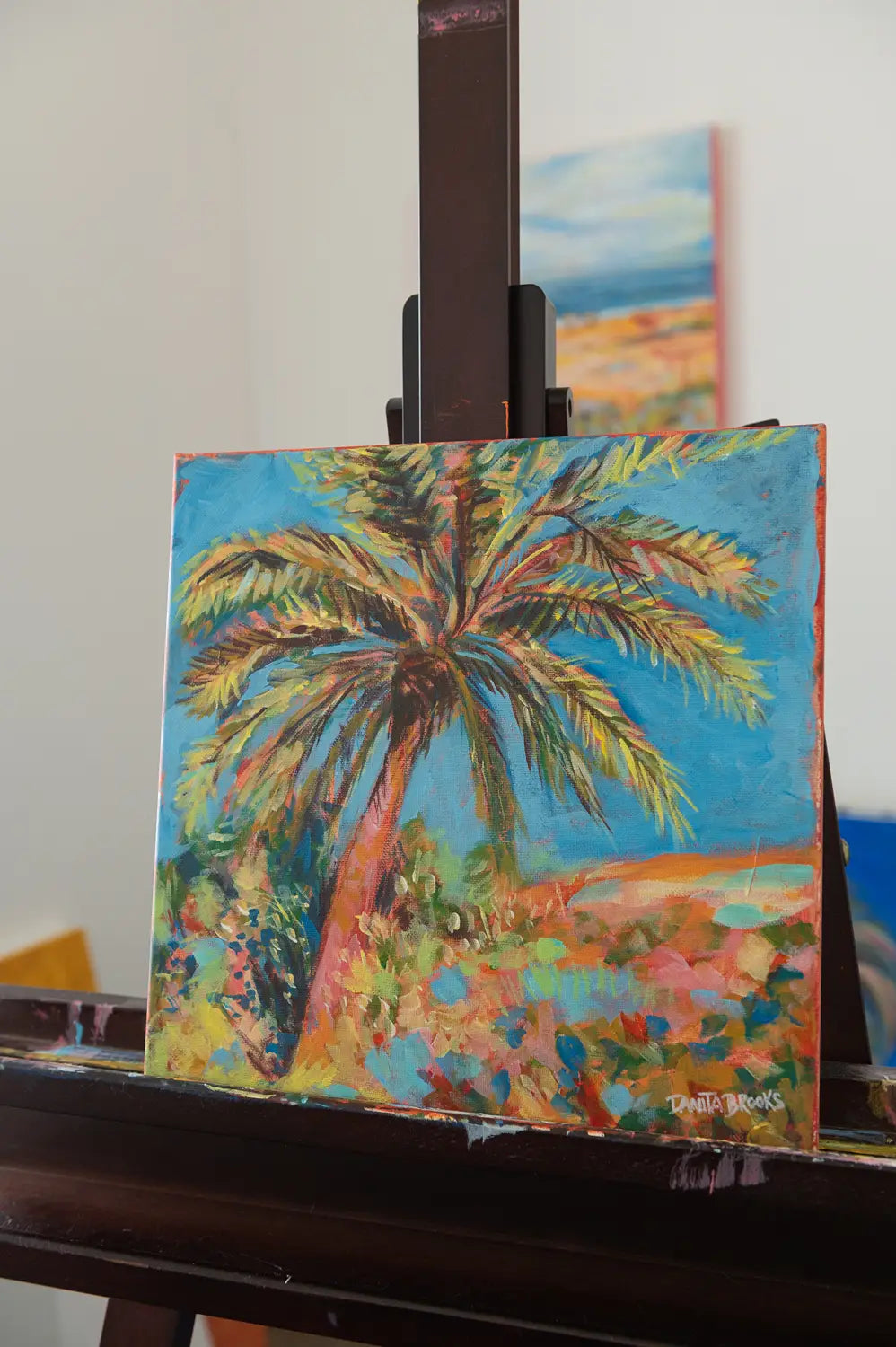 Side view of "Clear Skies Ahead" coastal painting showing a palm tree silhouette and open sky in soft blues