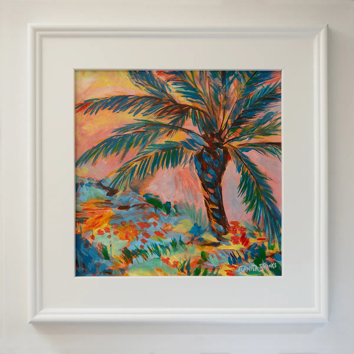 Original palm tree sunset painting titled "Sorbet Skies" by Danita Brooks, framed in white plein air frame and displayed in natural light