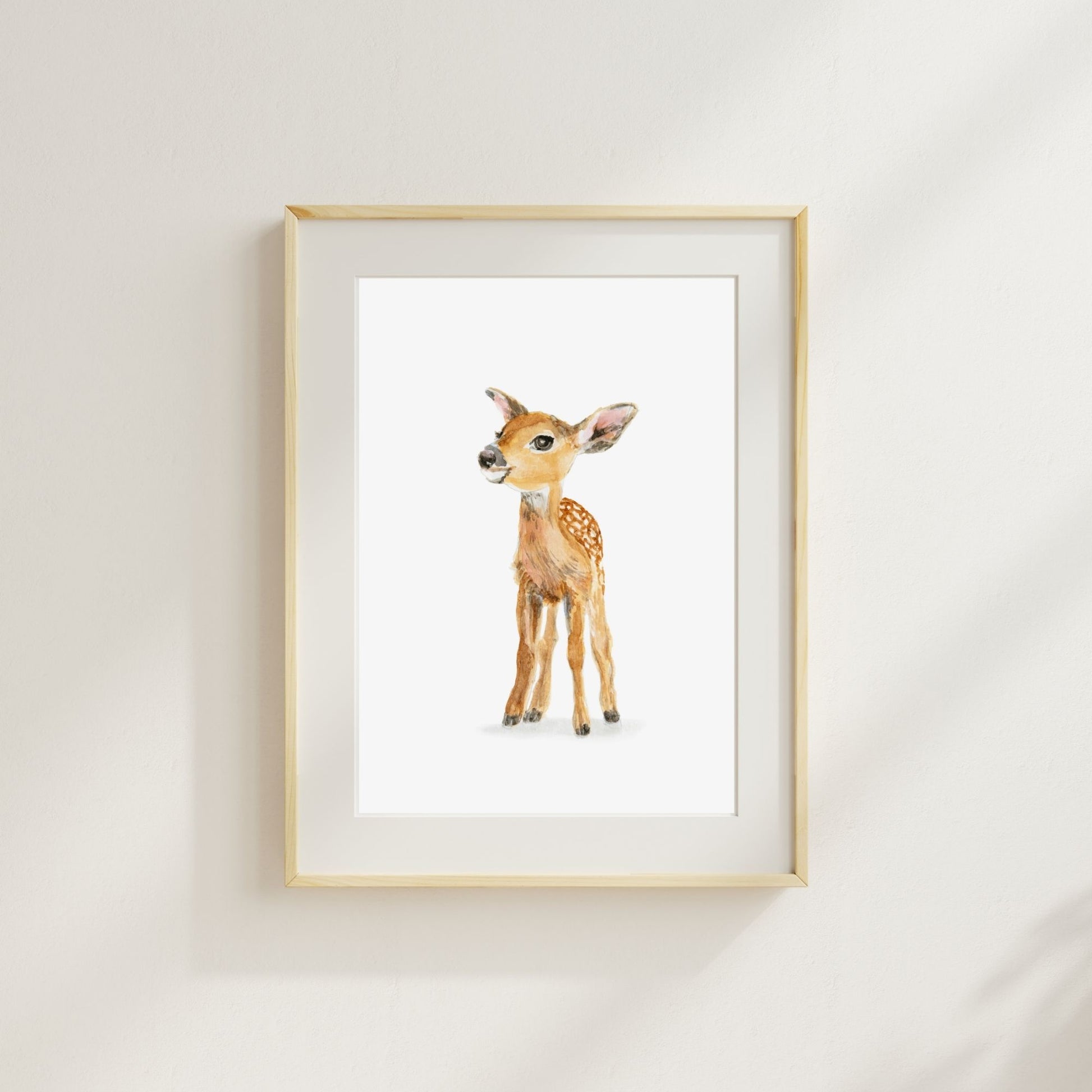 Woodland nursery art print - baby deer print a gentle forest animal wall art for children’s space here shown in a wood frame with a mat