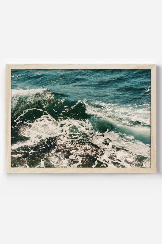 a picture of the ocean is hanging on a wall