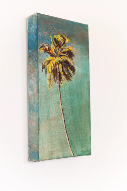 Side view of "The Long Way Home" palm tree painting on a white wall, showing the painted left edge and depth of the canvas.