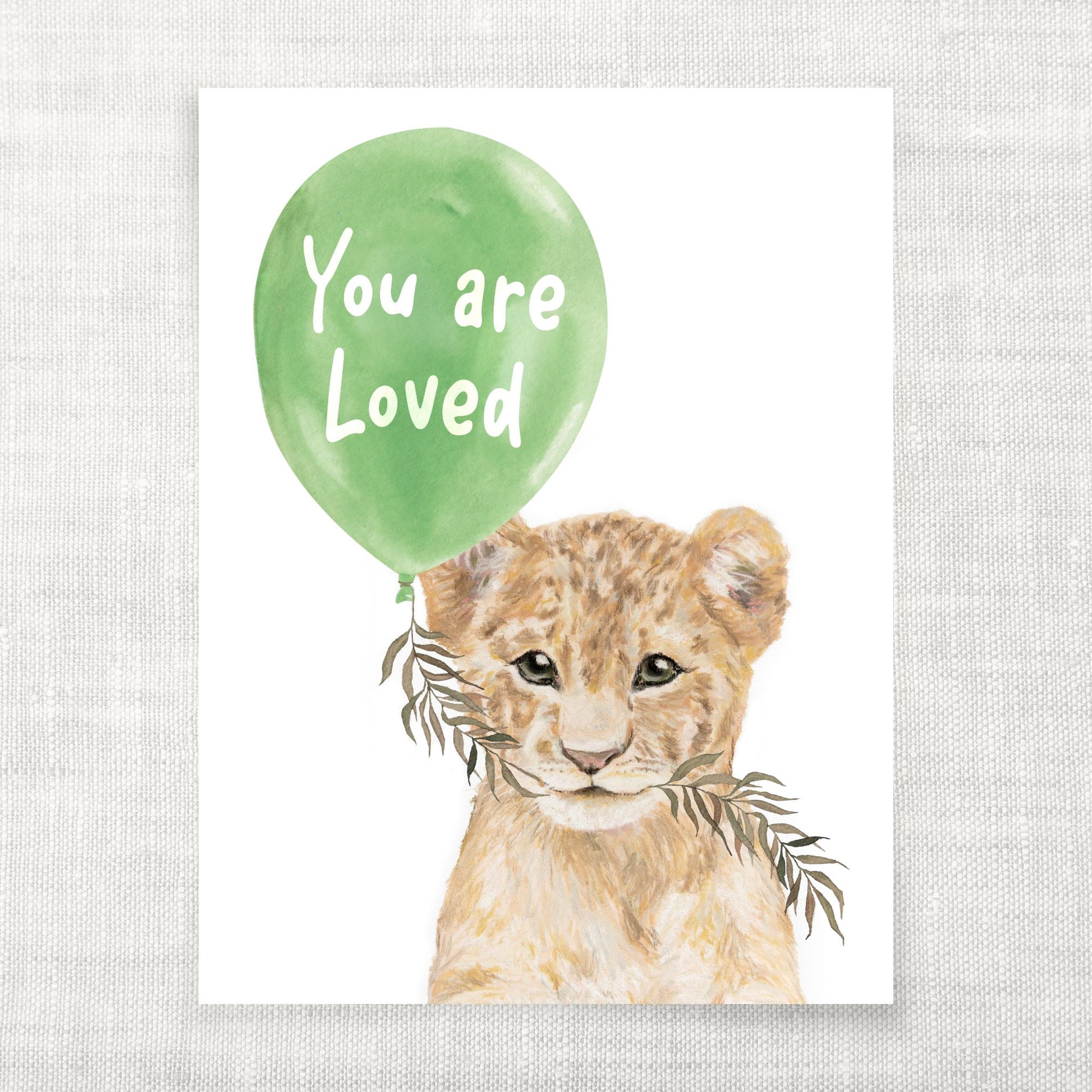 Illustration of a lion cub with a green balloon that says 'You are Loved' on a textured gray background.