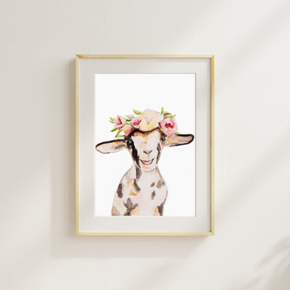 Framed artwork from Danita Brooks Studio of a watercolor goat with a floral crown art print on a white wall