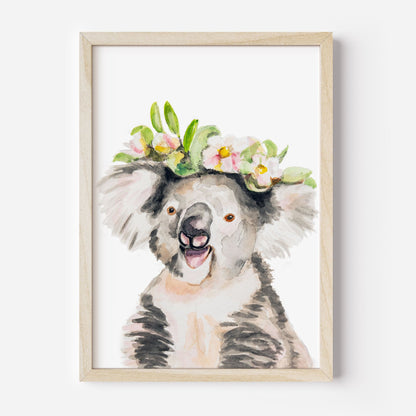 Framed artwork of a watercolor koala art print with a floral crown from Danita Brooks Studio on a white background