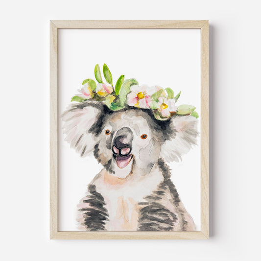 Framed artwork of a watercolor koala art print with a floral crown from Danita Brooks Studio on a white background