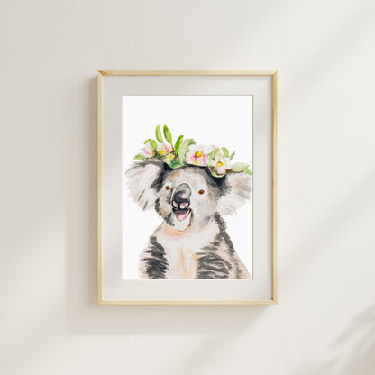 Framed artwork of a watercolor koala with a floral crown art print from Danita Brooks on a white wall